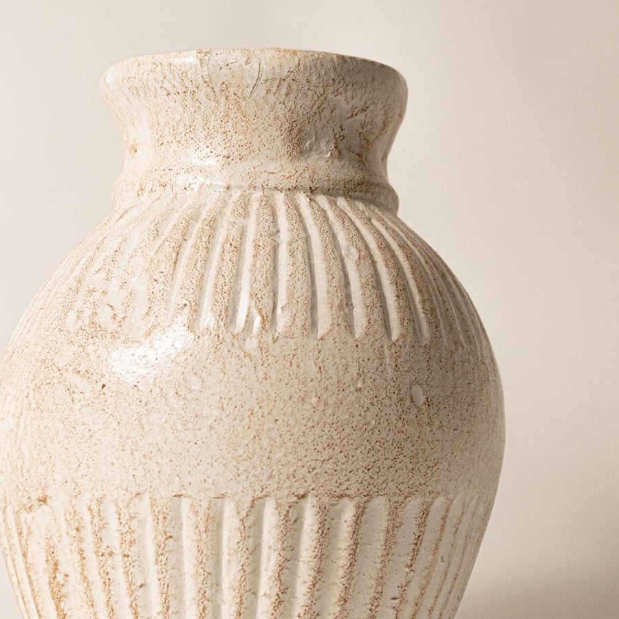 Close-up of ribbed vase showing fine ceramic texture soft glaze variations and artisan craftsmanship.