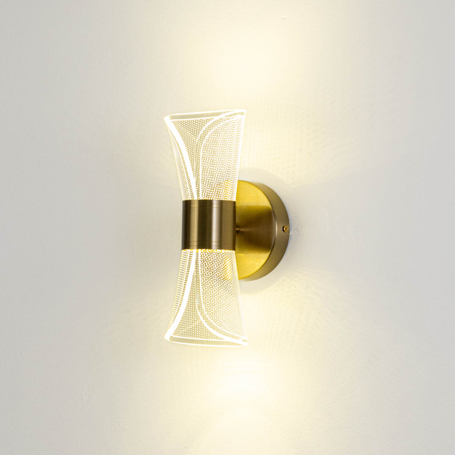 Minimal wall light in gold metal finish with sculpted glass design for bedroom or living decor lighting placement white background.