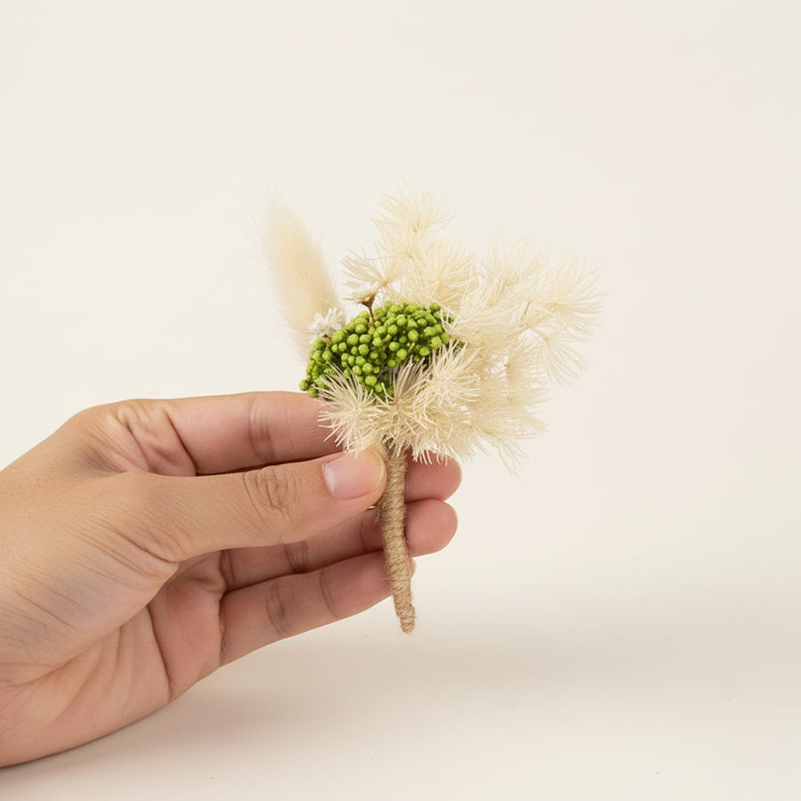 Dried mini floral bunch held by hand on white background showing natural texture soft tones and delicate handmade Decor detail.