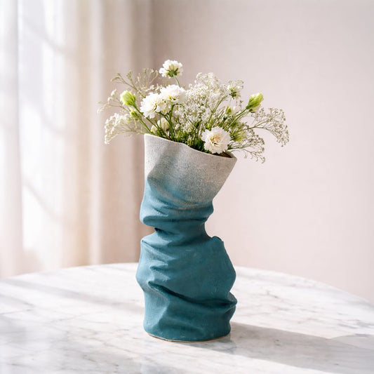 Blue ceramic flower vase with twisted textured design styled with fresh blooms for modern home decor placement.