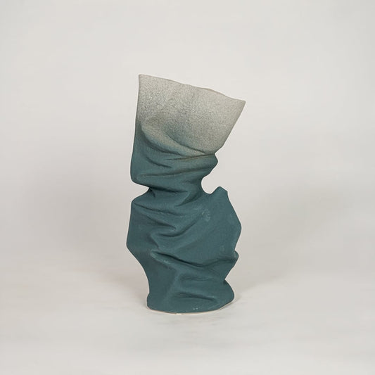 Blue ceramic decorative vase with abstract twisted design for modern console table and shelf decor placement.