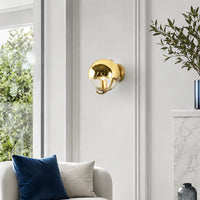 Modern gold metal wall light with reflective dome shade for elegant living room and luxury decor styling spaces.