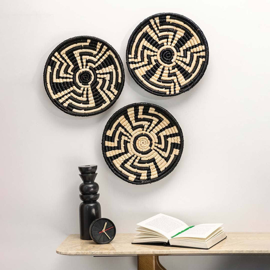 Handcrafted black and cream seagrass wall basket set with modern geometric patterns displayed in lifestyle living room.