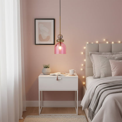 Glass pendant light in soft pink finish hanging above bedside table creating warm glow and charming modern bedroom lighting atmosphere.