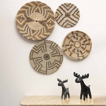 Handcrafted black and natural seagrass wall basket set with mixed geometric patterns in rustic lifestyle living room decor.