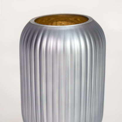 Close up view grey frosted glass vase with ribbed texture and gold inner finish luxury decorative glass accent for shelf styling home.
