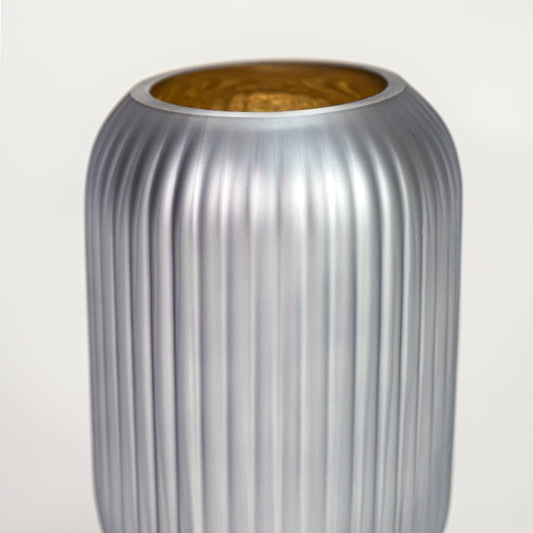 Close up view grey frosted glass vase with ribbed texture and gold inner finish luxury decorative glass accent for shelf styling home.
