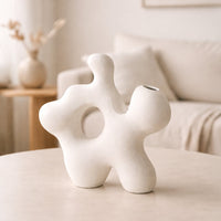 White ceramic abstract decorative sculpture styled on a coffee table for elegant modern home decor and styling.