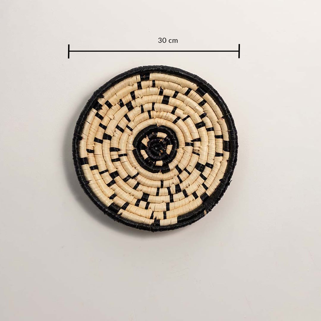 A handwoven natural and black rattan wall decor plate displayed on a white background with a clear diameter of 30 cm for accurate wall decor measurement and placement.