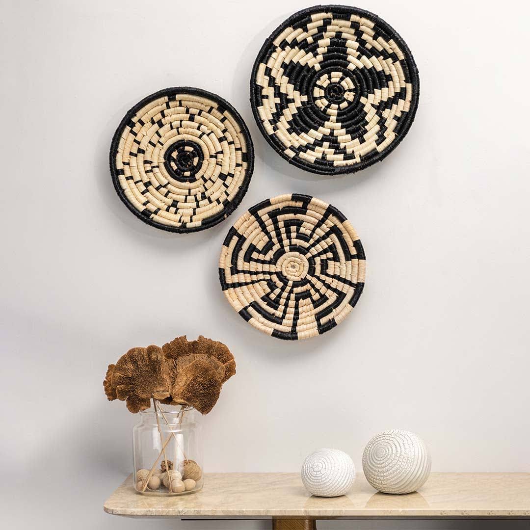 Woven black and cream seagrass wall basket set with geometric patterns in artisan lifestyle living room wall décor styling.
