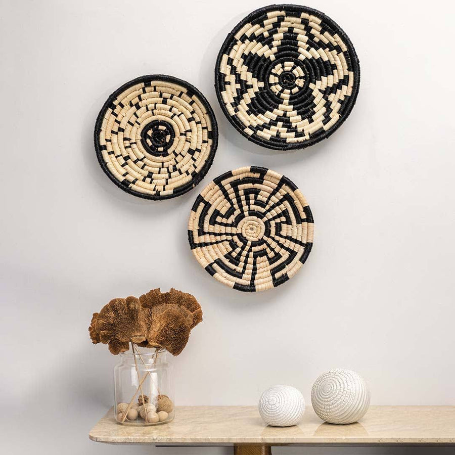 Woven black and cream seagrass wall basket set with geometric patterns in artisan lifestyle living room wall décor styling.