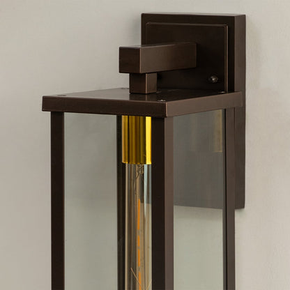 Closeup of bronze outdoor wall lantern showing clear glass body and warm glowing bulb perfect for enhancing modern porch patio and home exterior Decor.