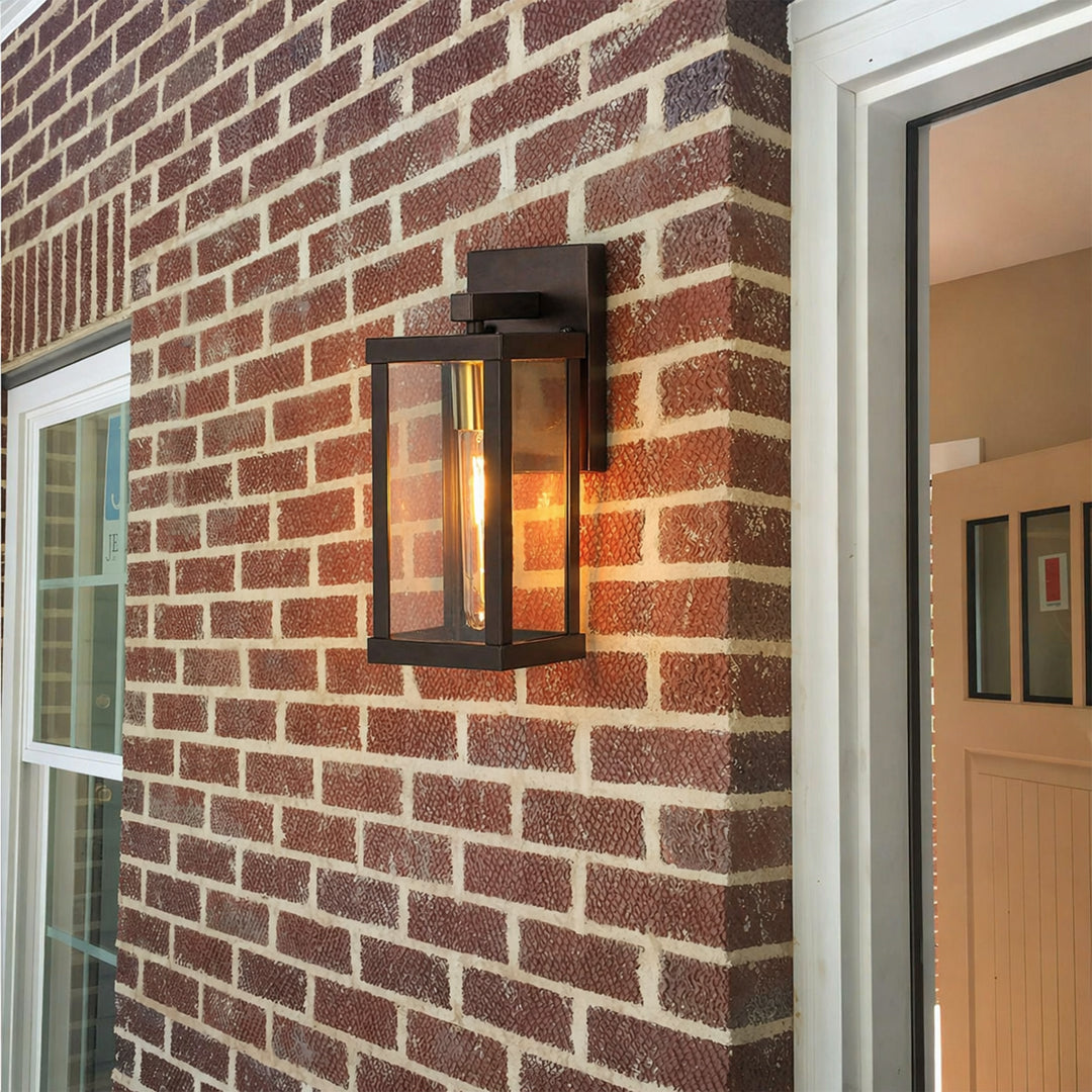 Modern black rectangular outdoor wall light lifestyle image with clear glass panels mounted on a red brick entryway wall.