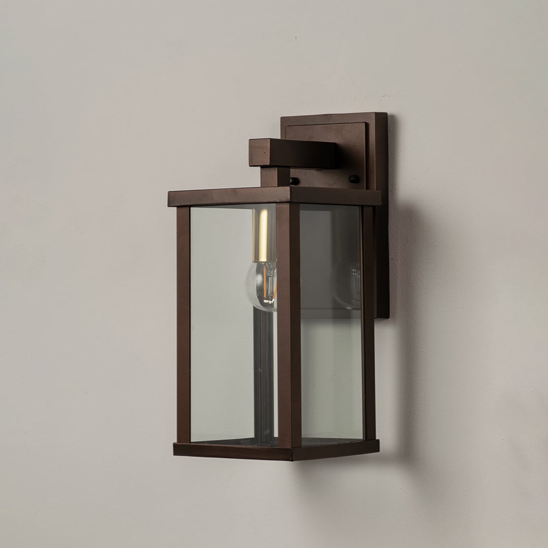 Sleek metal wall lantern on white background with clear glass panels highlighting modern outdoor wall lighting decor.