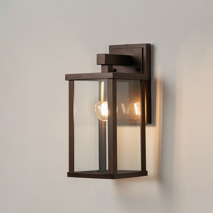 Black metal outdoor wall light on white background with clear glass shade for minimalist patio lighting decor.