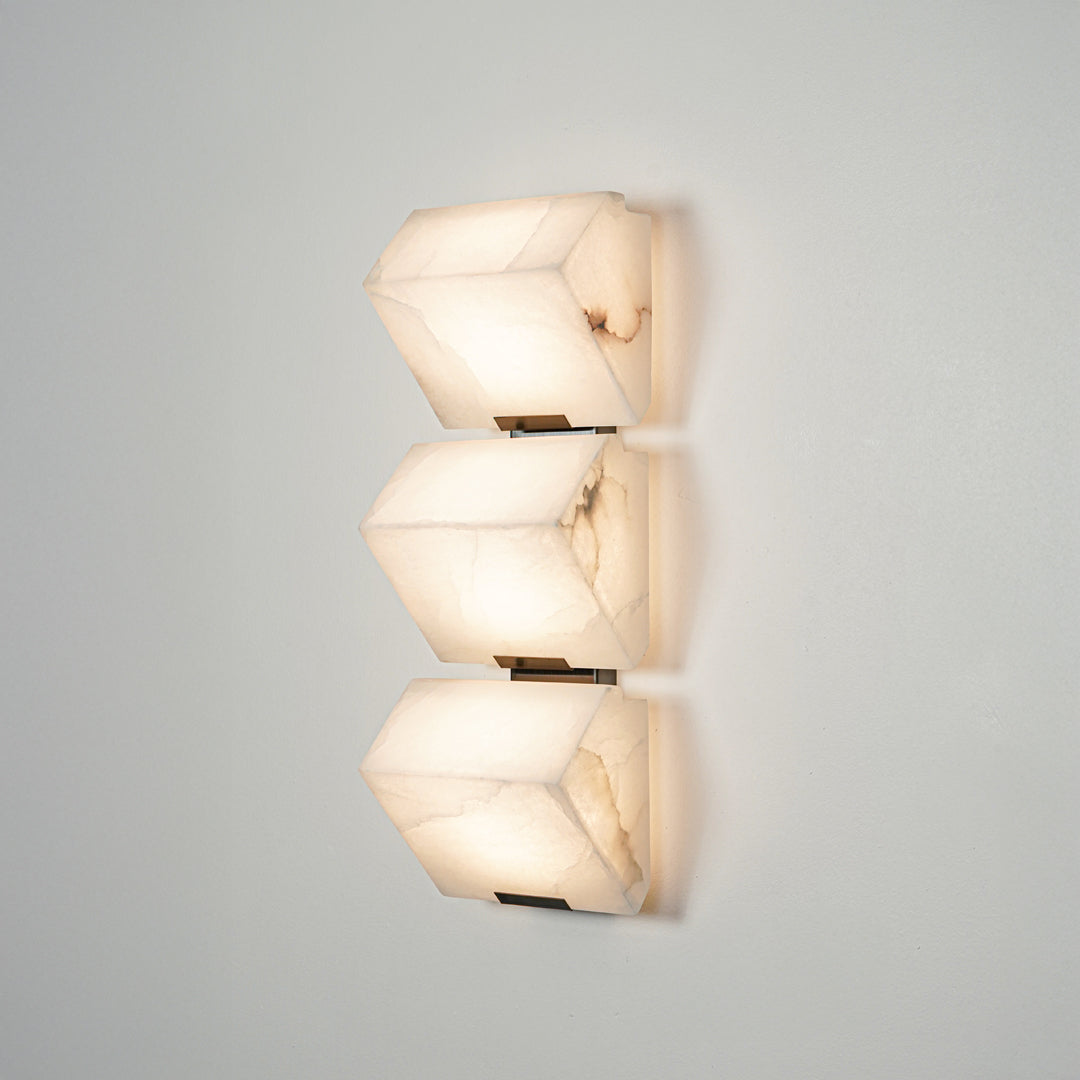 Contemporary wall sconce with layered frosted glass elements creating soft ambient glow perfect for stylish home decor lighting.

