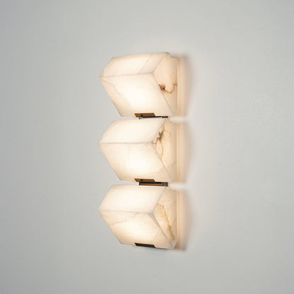 Contemporary wall sconce with layered frosted glass elements creating soft ambient glow perfect for stylish home decor lighting.

