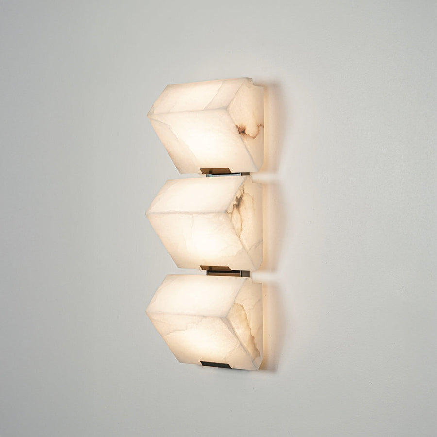 Contemporary wall sconce with layered frosted glass elements creating soft ambient glow perfect for stylish home decor lighting.

