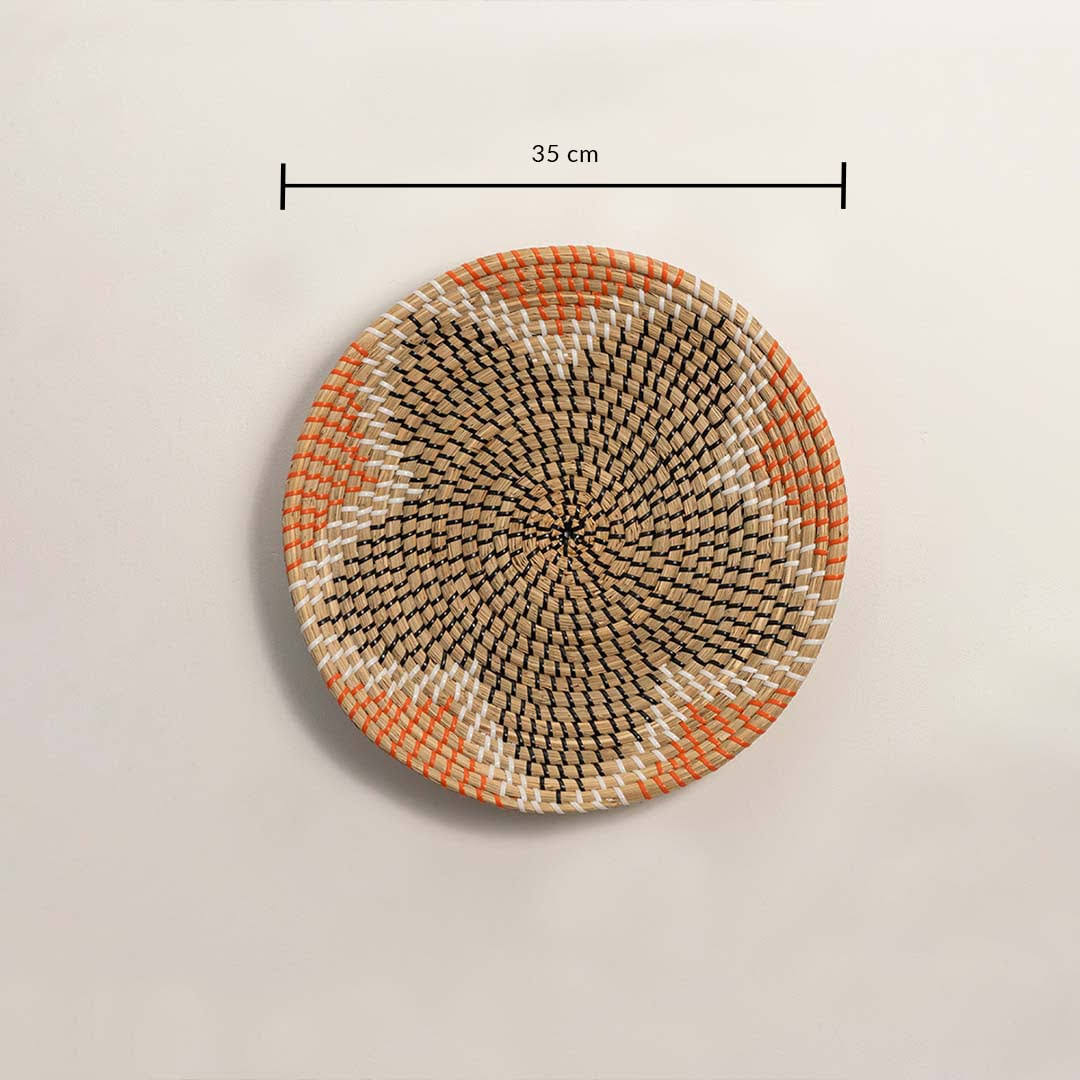 Dimension image of handcrafted natural seagrass wall basket with orange and black geometric star pattern for boho decor.