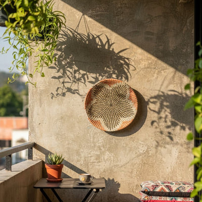 Round woven wall decor in natural tone mounted on patio wall creating warm shadows and artisanal character in outdoor living area.