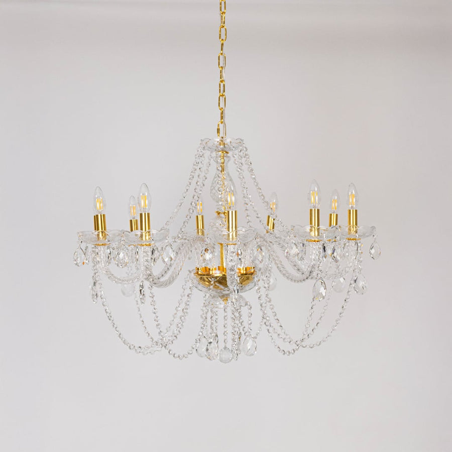 Classic chandelier with crystal and gold finish shown off on white background for modern home decoration.