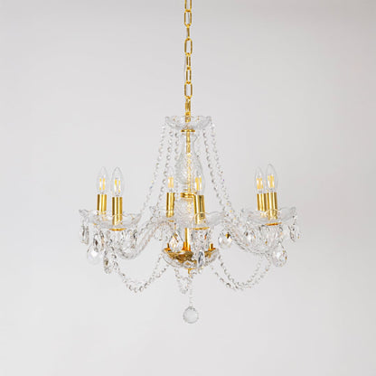 Classic chandelier with crystal and gold finish displayed off on white background for decorative lighting.