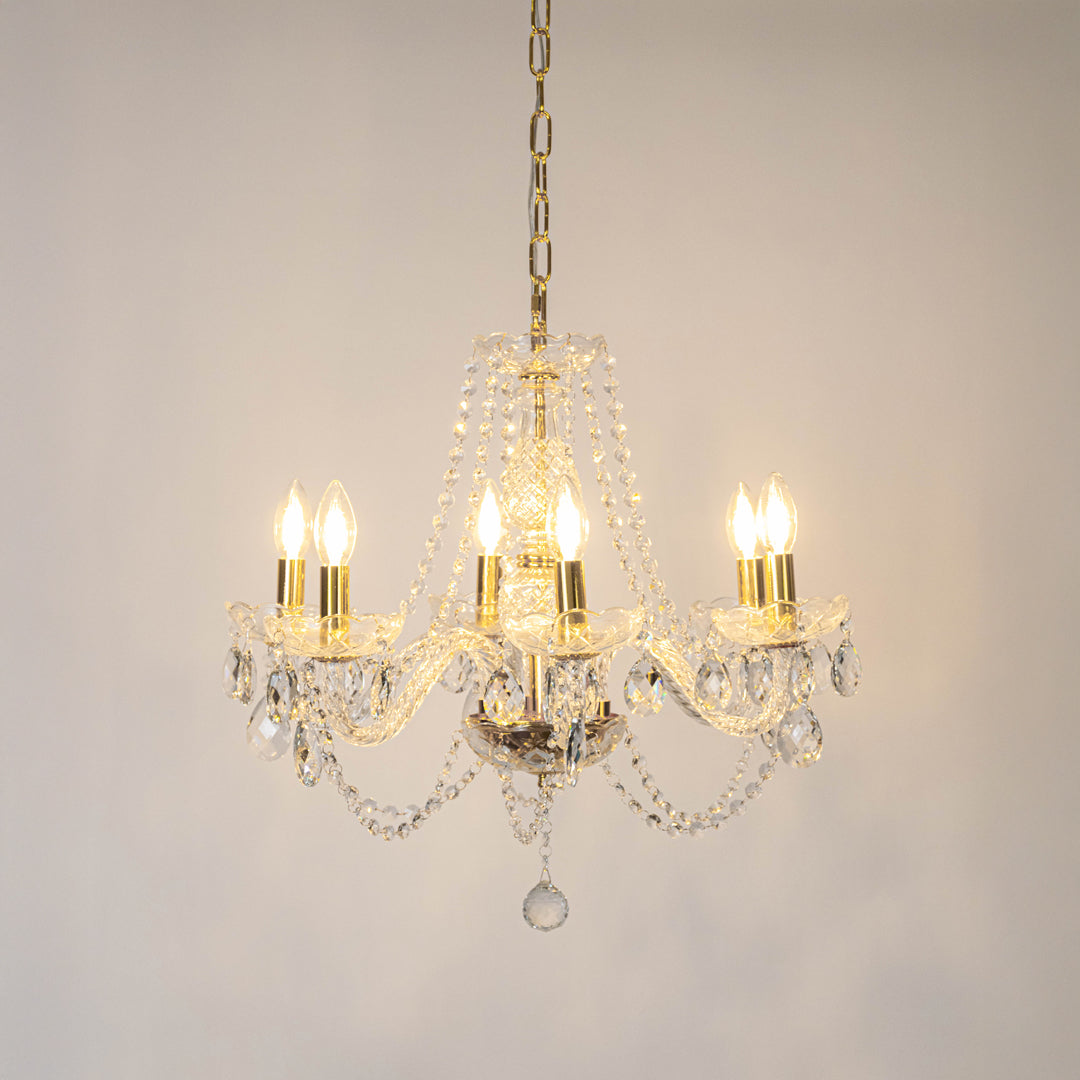 Clear crystal chandelier with illuminated candle bulbs and sparkling crystal drops creating luxurious traditional ceiling lighting.