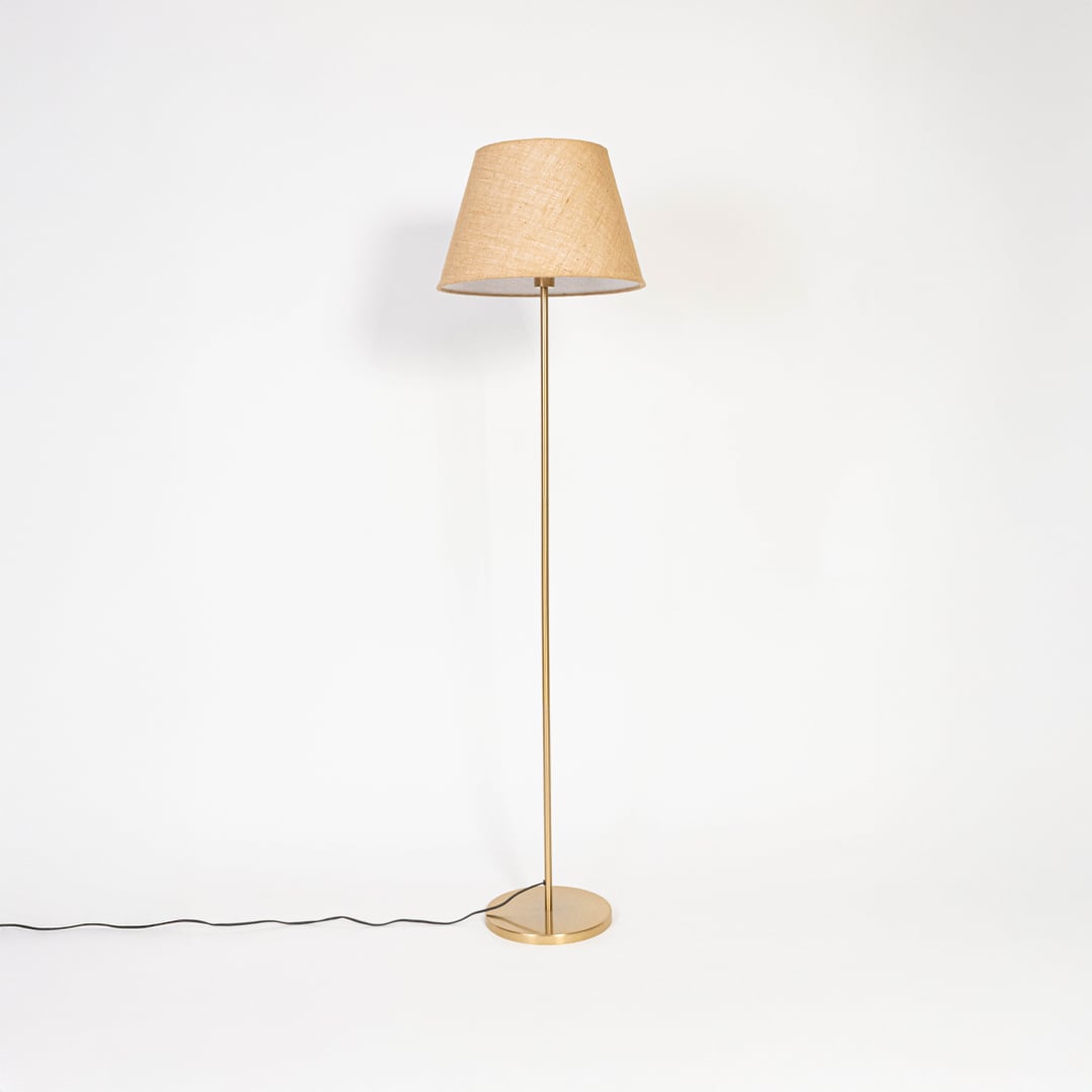 Beige shade floor lamp with golden base displayed with light off against white background.