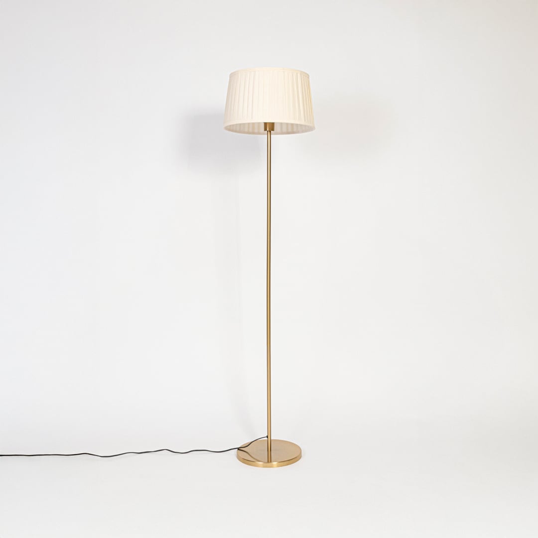 Floor lamp with white pleated fabric shade and golden stand displayed on white background with light off.