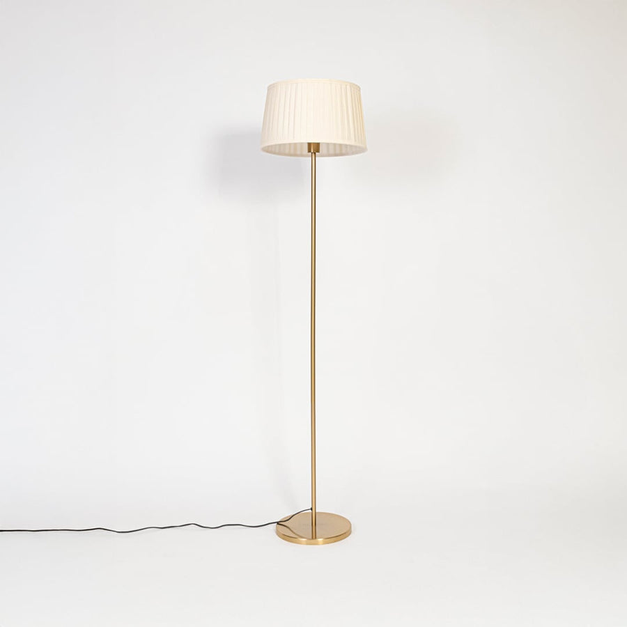 Floor lamp with white pleated fabric shade and golden stand displayed on white background with light off.
