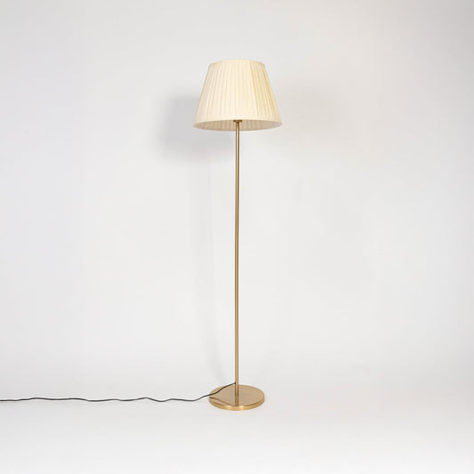 Golden floor lamp with pleated white fabric shade displayed turned off on plain white background.