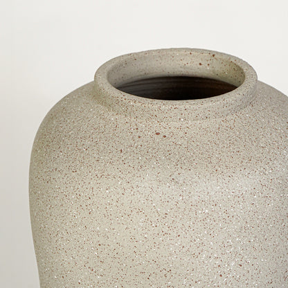 Closeup image of beige ceramic rustic vase for modern tabletop decor styling with artistic textured finish.