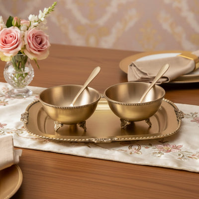 Gold metal condiment bowl set lifestyle image with serving spoons for elegant luxury dining table decor.