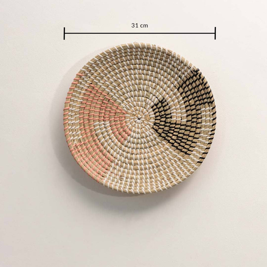 Dimension image of handcrafted natural seagrass wall basket with pink and black color block pattern for boho wall decor.