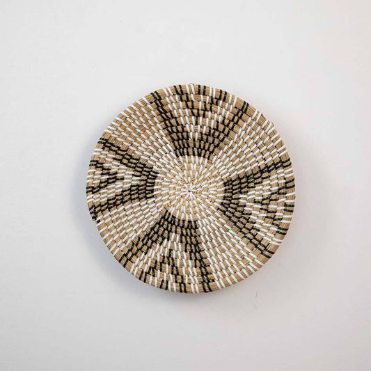 Handwoven seagrass round wall basket decor in natural beige and black with geometric woven pattern displayed on white background.
