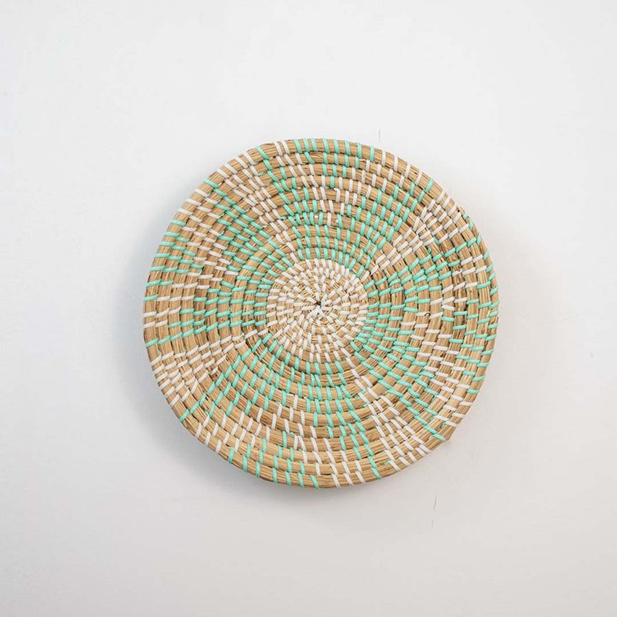 Mint green and natural woven decorative wall basket with floral pattern for elegant wall styling and modern home decor.