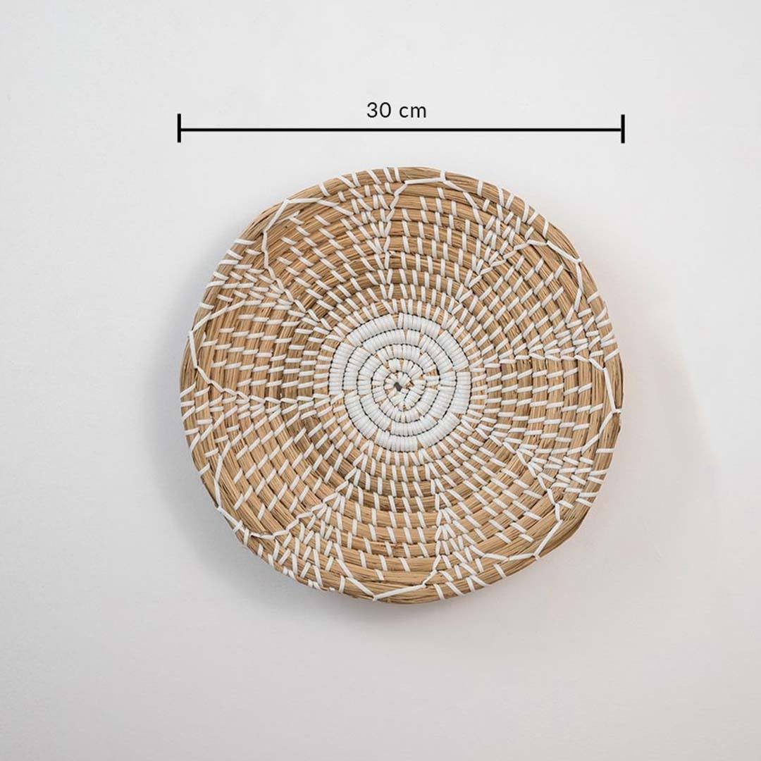 Handwoven seagrass round wall basket decor in natural beige with white spiral woven pattern and size guide on white.