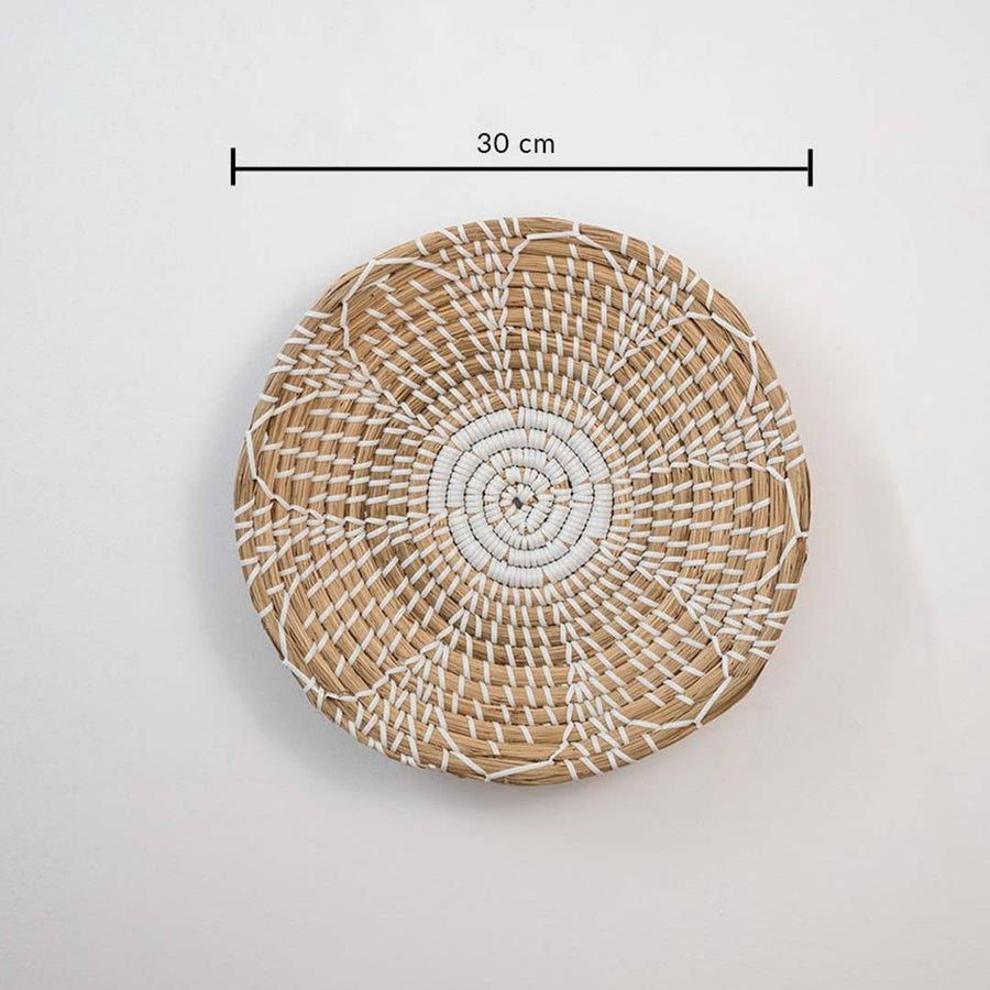 Handwoven seagrass round wall basket decor in natural beige with white spiral woven pattern and size guide on white.