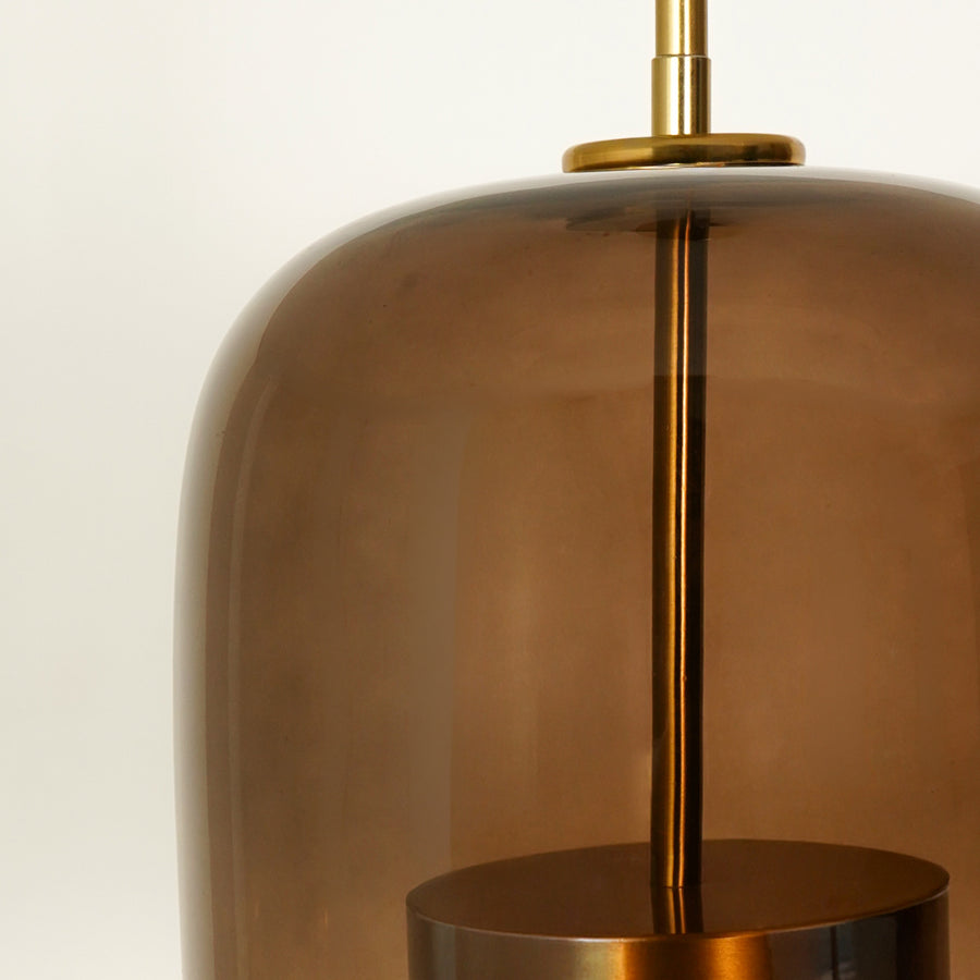 Closeup image of round shade sunbeam glass pendant light for elegant living room decor styling highlighting sleek glass finish.