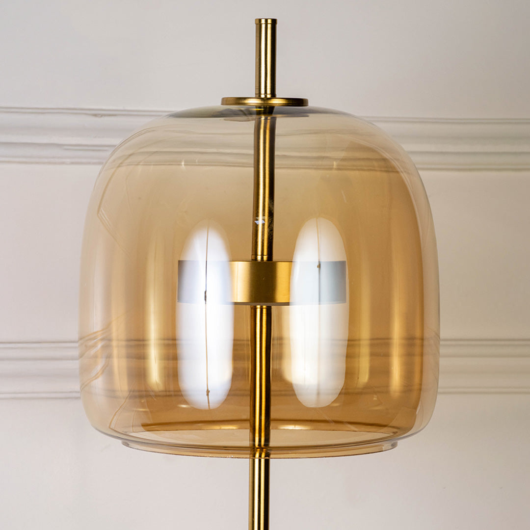 Decorative pendant light in gold metal finish with amber glass shade for dining room or kitchen decor lighting white background.
