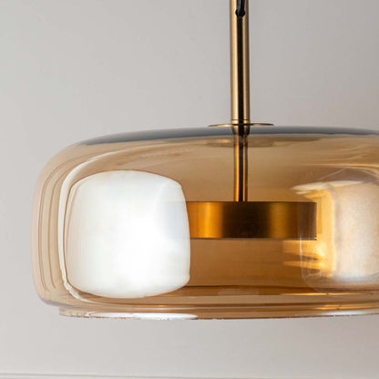 Close view amber glass pendant light with white diffuser and gold finish modern hanging lamp for decor lighting.