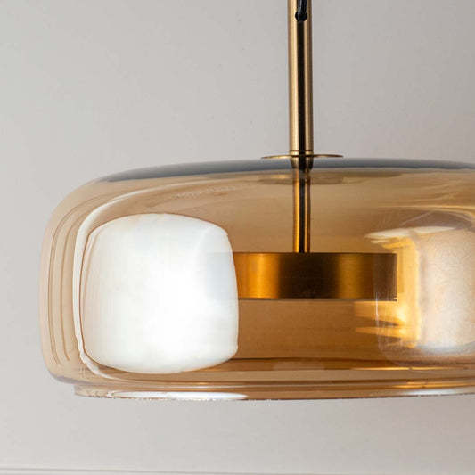 Close view amber glass pendant light with white diffuser and gold finish modern hanging lamp for decor lighting.