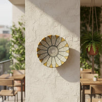 Handcrafted round metal wall decor in gold and grey finish mounted on balcony wall adding artistic texture and elegant outdoor lifestyle accent.