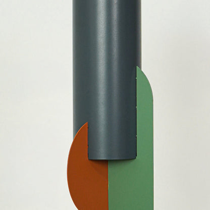 Closeup of charcoal metal pendant light highlighting orange and green glass accents and craftsmanship.