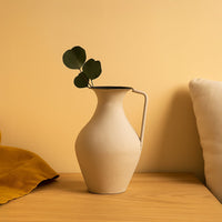 Cream metal tall jug vase decor styled in a warm modern room adding an elegant accent to living room tables and corners.