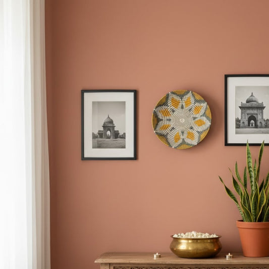 Round metal wall decor in gold grey finish mounted on peach wall creating refined focal point and stylish lifestyle accent for living room.