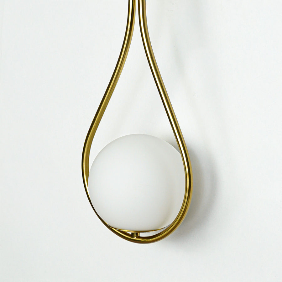 Closeup of white glass and gold metal wall light for modern hallway and premium decor styling spaces.