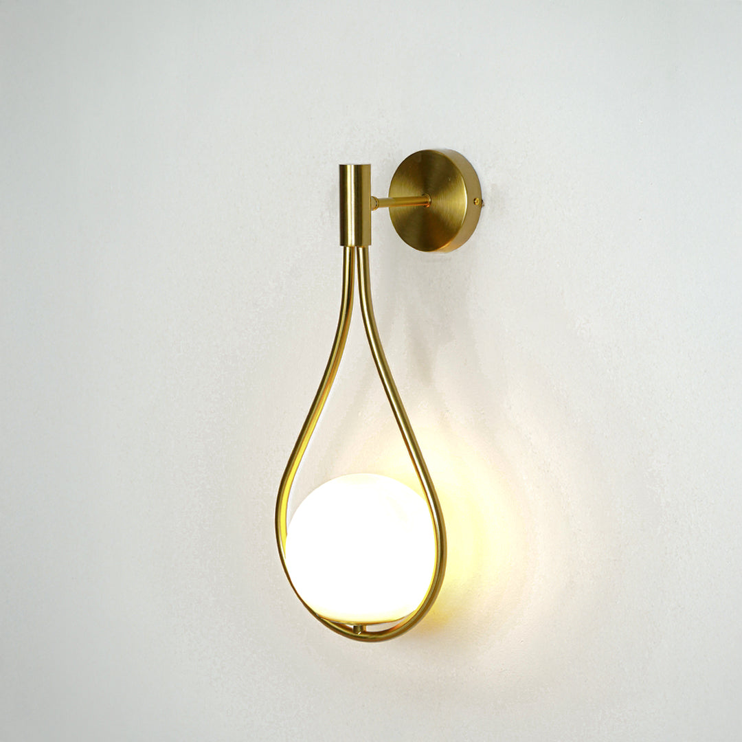 Modern gold metal wall light with warm ambient glow for stylish bedroom and luxury decor spaces.

