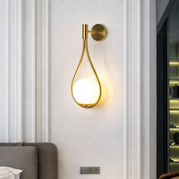 Modern gold metal wall light with white glass globe for elegant bedroom and luxury decor styling spaces.

