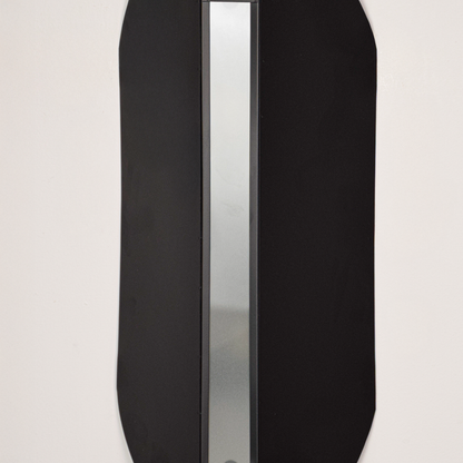 Wall light closeup highlighting smooth black metal finish with soft glowing center showcasing premium craftsmanship and architectural design.